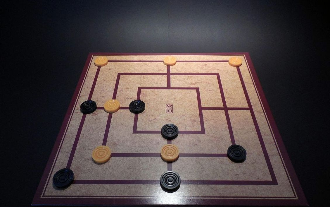 alt: Un tablero de Catan con piezas de madera y dados listos para jugar